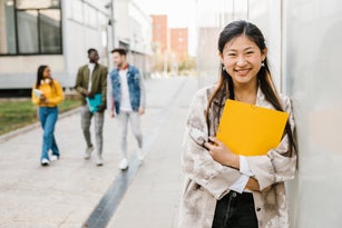 Cheerful young asian female student smiling at camera