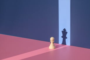 Pawn chess piece with king shadow