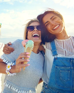 Laughing teenage girls enjoying ice cream cones