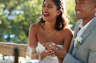 Happy married couple holding hands at winery