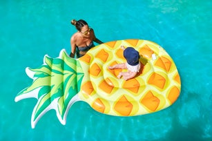 Mother with her baby on float in the pool