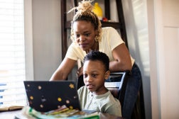 Mother helping son during e-learning at home