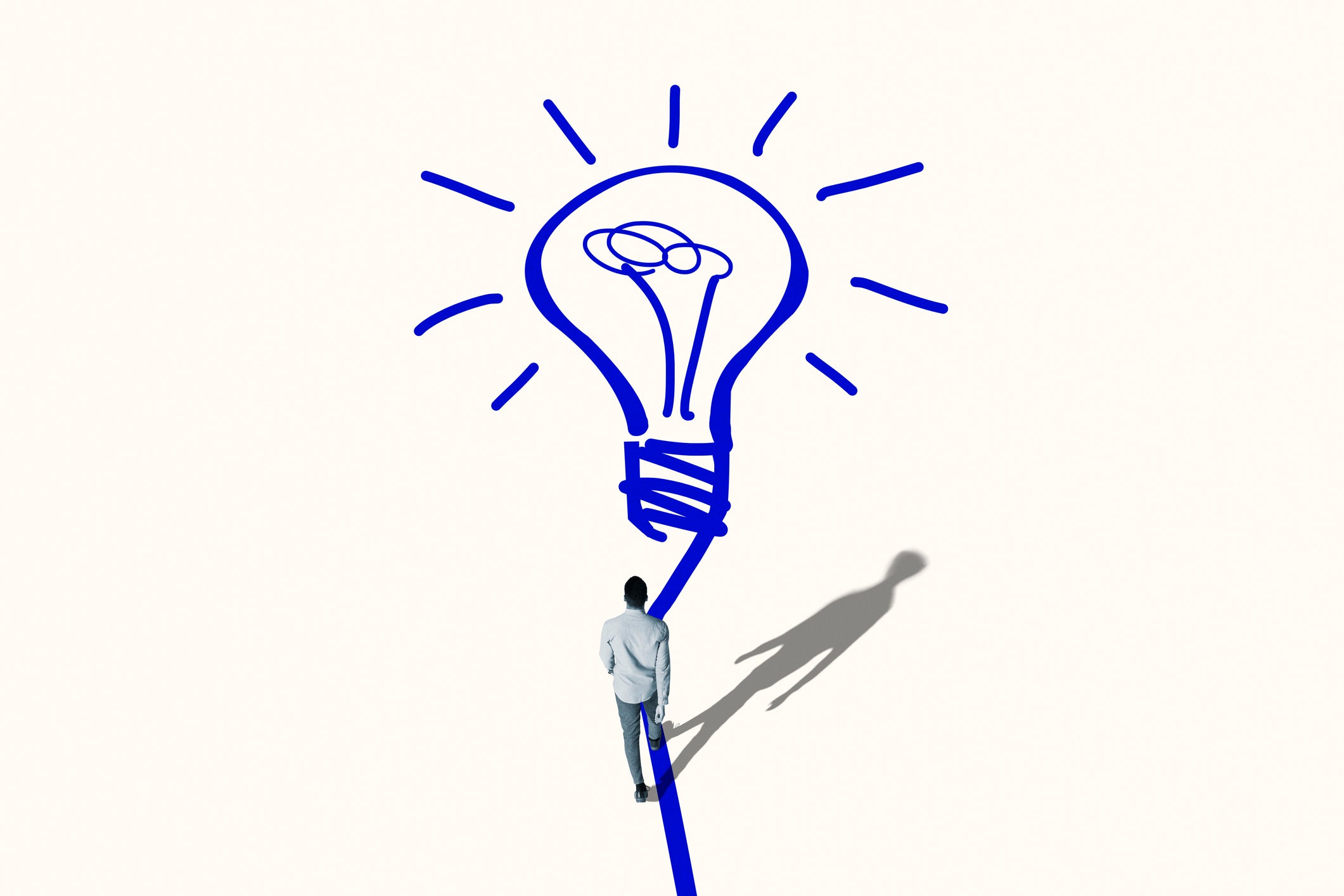 Young man walking towards bright blue bulb