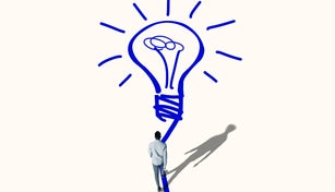 Young man walking towards bright blue bulb