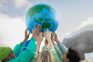 Group of teenagers holding up the world