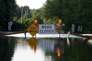 A road closure signage as water covers the road