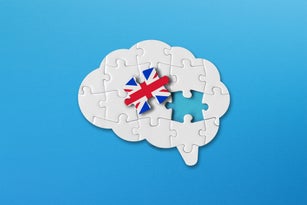 English learning concept, white jigsaw puzzle pieces with british flag a human brain shape on blue background
