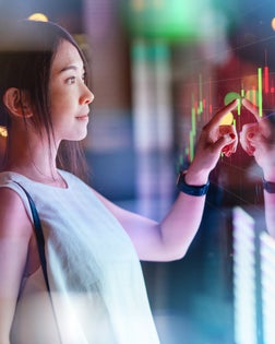 Young woman touching screen on futuristic digital display.