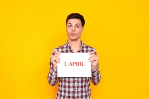 Shocked man holding white table with an inscription 1 april