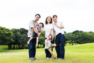 A family taking a walk in the neighborhood park in the evening