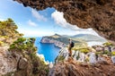 Capo Caccia, hiker admiring the view from a cave. Sardinia, Italy