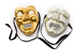 A gold and silver theater mask with black ribbons