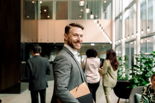 Side view portrait of smiling male entrepreneur in lobby at convention center