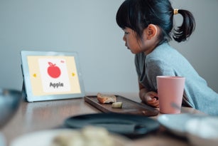 Young Girl Studying At Home With Digital Tablet.