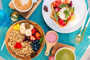 Healthy breakfast with smoothie bowl and waffle with salmon and poached egg
