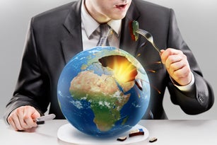 Greedy businessman eating planet Earth