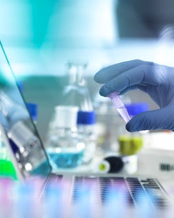 Research experiment, scientist examining vial containing sample used in biomedical, DNA, biotechnology, analytical chemistry and pharmaceutical research