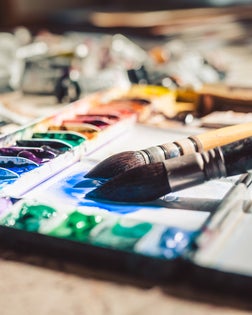 Colour mixing on a watercolour pallette in artist studio.