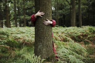 Child hugging tree.