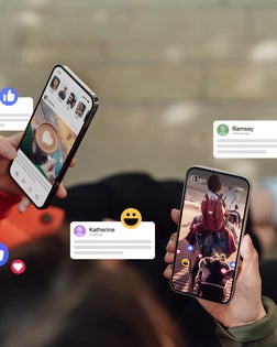 Closeup of two friends commenting and giving likes on social media platform via smartphone