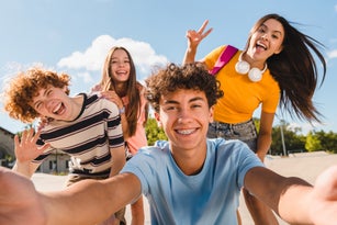 Selfie shot of crazy young people having fun together spend summer weekend in skate park outside