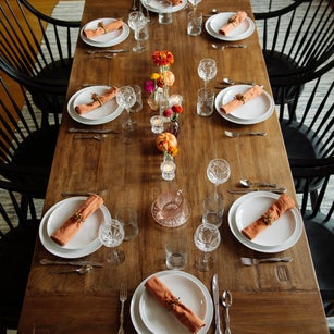 Plates with wineglasses arranged on dinner table in dining room