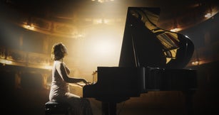 Portrait of a Talented Asian Pianist Captivating Audience with a Masterful Performance on a Grand Piano. Under Soft Stage Lights, Her Fingers Move Across the Keys, Creating Beautiful Classical Music