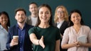 Woman company representative holds out hand for handshake welcoming client