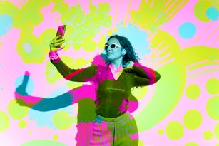 Woman with eccentric clothing and sunglasses take a selfie