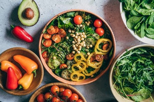 Close up of woman's hand holding a bowl of fresh beef cobb salad, serving on the dining table. Ready to enjoy her healthy and nutritious lunch with coffee. Maintaining a healthy and well-balanced diet. Healthy eating lifestyle
