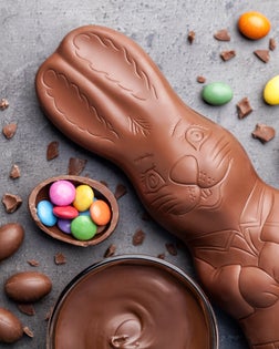 Chocolate Easter bunny and eggs on rustic background