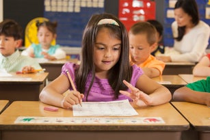 Mixed race student studying at desk in classroom