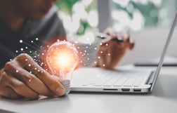 Male hand holding illuminated light bulb of new ideas with innovative technology and creativity