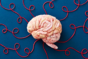 A human brain made of wool with string representing neural pathways