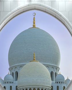 Artistic image of the main entrance to majestic Sheikh Zayed Grand Mosque at late dusk in Abu Dhabi, United Arab Emirates