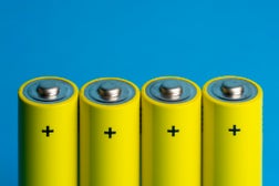 Four Yellow Batteries On Blue Blackground