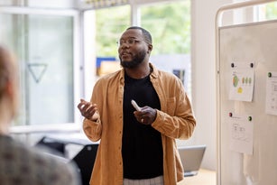 African man giving a presentation to the team at coworking office