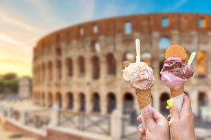Colosseum at sunset in Rome, Italy with italian ice cream gelato in hands. World famous landmark in Italy
