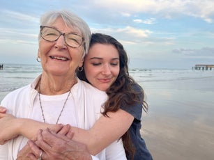 Grandmother and teenager on a walk at the beach on a family weekend getaway.