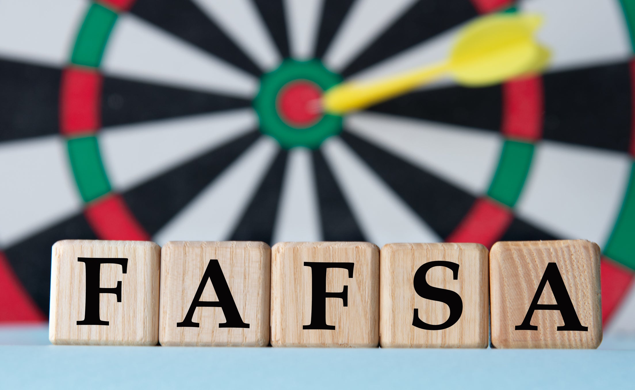FAFSA - acronym on wooden cubes on dartboard background