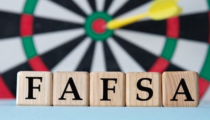 FAFSA - acronym on wooden cubes on dartboard background