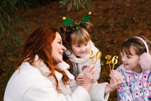 Happy family celebrating New Year with golden “2026” numbers outdoors