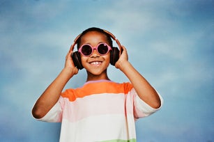 Happy boy listening to music through headphones