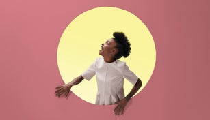 Woman laughing, placed inside round opening in coloured wall