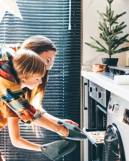 Happy mother and son baking Christmas cookies.