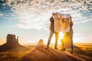 Hispanic couple reading map in remote desert
