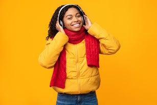 Black Woman Listening Music In Earphones On Yellow Studio Background