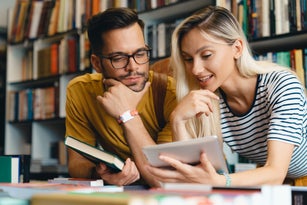 Happy young university students friends studying with tablet at university - Stock Photo