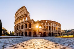 Sun shining through the arches of Coliseum at sunrise, Rome, Italy