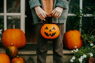 boy holding a halloween cup full of candies